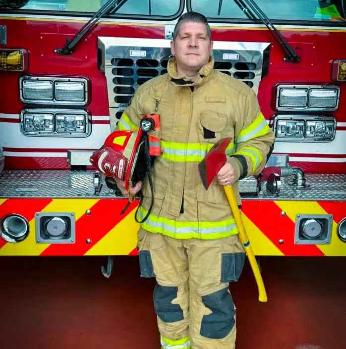 Firefighter standing in front of fire truck